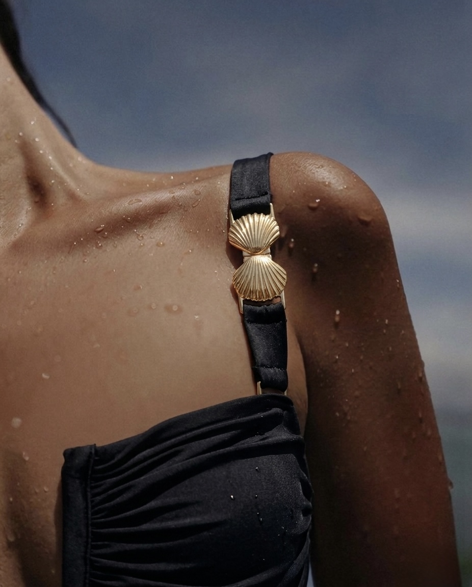 Black one-piece swimsuit with gold seashell strap detail